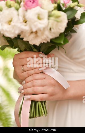 Die Hände der Frauen halten einen Blumenstrauß. Nahaufnahme Stockfoto