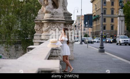 Wunderschönes Mädchen, das Architektur bewundert, während er auf einer Brücke in Rom, Italien, steht Stockfoto