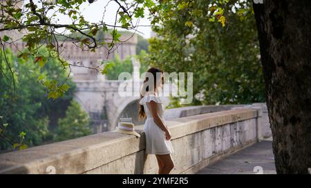 Elegante Frau, die die Natur und die historische Aussicht am Ponte Sant Angelo in Rom genießt Stockfoto