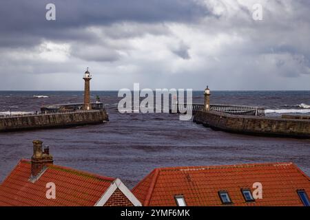 Sturmwolken sammeln sich über den zwei Leuchttürmen von Whitby Harbour, North Yorkshire, England. Stockfoto