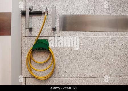 Feuerlöschschlauch hängt an der Wand im Zimmer Stockfoto