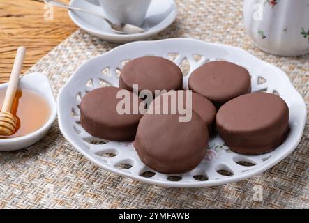 Brasilianisches Pao de Mel oder mit Schokolade überzogene Honigkekse über einem Holztisch. Stockfoto