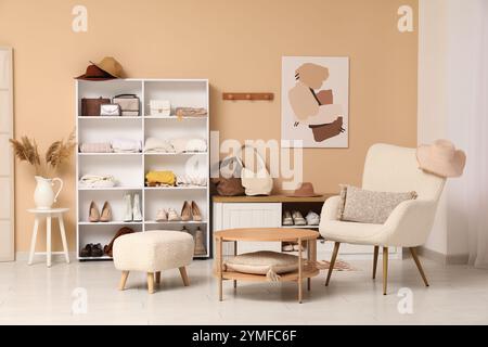 Stilvolle Einrichtung des Ankleidezimmers mit gefalteter Kleidung, Schuhen und Accessoires Stockfoto