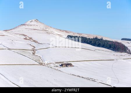 Shutlingsloe Hill in einer schneebedeckten Winterlandschaft des Cheshire Peak District mit einem einsamen Bauernhaus Stockfoto