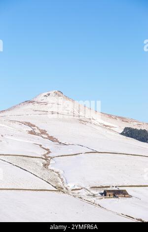 Shutlingsloe Hill in einer schneebedeckten Winterlandschaft des Cheshire Peak District mit einem einsamen Bauernhaus Stockfoto