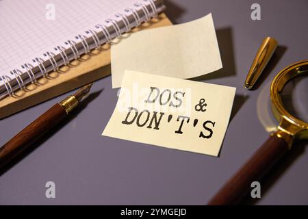 Botschaft zu tun und nicht zu tun. Text auf gelbem Papier auf gerissenem Papier. Stockfoto