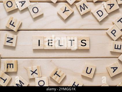 Das Bild zeigt eine Collage aus Holzblöcken, die IELTS beschreiben und das International English Language Testing System symbolisieren, das oft für Academ verwendet wird Stockfoto