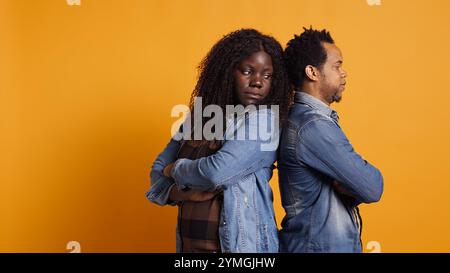 Traurige Ehemann und Ehefrau bereuen sich, im Studio gegeneinander zu kämpfen und sich nach einem Missverständnis zurückzuhalten. afroamerikanisches Paar mit Eheproblemen, Streit. Kamera B.. Stockfoto