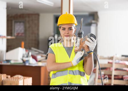 Bauingenieurin mit pneumatischem Hackhammer auf der Baustelle Stockfoto