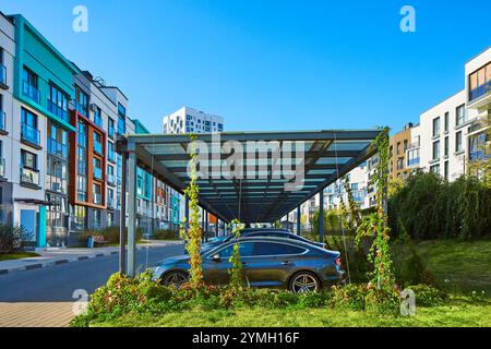 New Metal Carport für öffentliche Fahrzeug Parken vor Multi Wohngebäude. Parkplatz im Freien mit Auto. Stockfoto