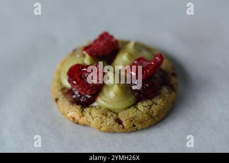 Nahaufnahme von hausgemachtem amerikanischem Keks mit Pistazien und Himbeeren. Dekoriert mit frischen Himbeeren, Marmelade und Pistaziencreme. Stockfoto
