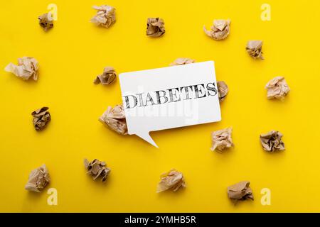 Gelber Hintergrund mit einem weißen Schild, auf dem Diabetes steht. Das Schild ist von geschreddertem Papier umgeben Stockfoto