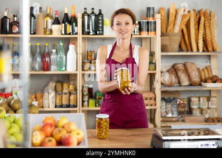 Eine Erwachsene Verkäuferin bietet Oliven im Supermarkt an Stockfoto
