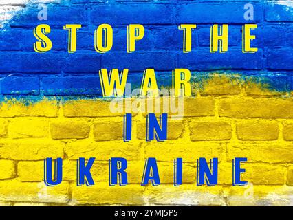 Blaues und gelbes Schild mit der Aufschrift Stop the war in Ukraine. Das Schild ist an einer Mauer Stockfoto