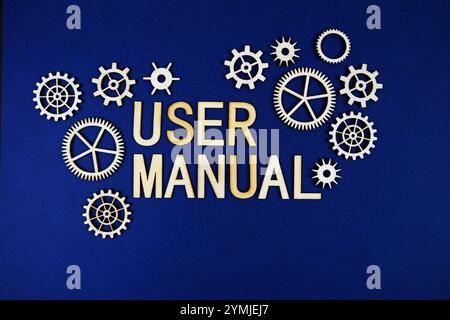 Buchstaben in Buchstaben im Benutzerhandbuch mit Zahnrädern auf marineblauem Hintergrund Stockfoto