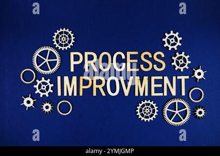 Prozessverbesserungsbuchstaben mit Zahnrädern auf marineblauem Hintergrund Stockfoto