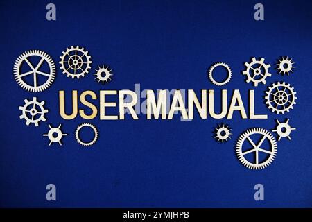 Buchstaben in Buchstaben im Benutzerhandbuch mit Zahnrädern auf marineblauem Hintergrund Stockfoto