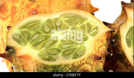 Eine Nahaufnahme einer gehörnten Melone, die ihr lebhaftes grünes Inneres und das strukturierte orangefarbene Äußere unterstreicht und die einzigartige und exotische Anziehungskraft der Frucht zeigt Stockfoto