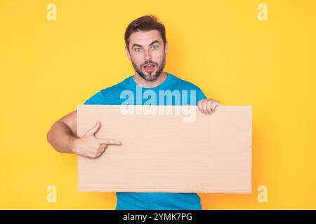 Ein gutaussehender Mann mittleren Alters mit leerem Plakat. Darstellung des Kopierbereichs für Ihren Text oder Ihr Design. Ein Mann, der eine leere Werbetafel im Studio zeigt Stockfoto