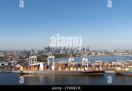 Melbourne Australien. Der Blick auf den Hafen von Melbourne mit Containerschiff auf dem Yarra River und die Stadt im Hintergrund. Stockfoto