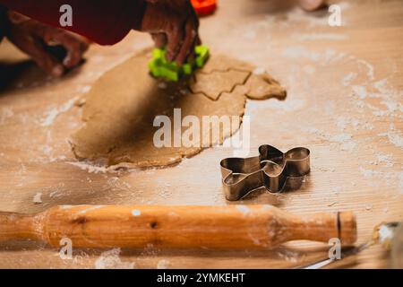 Weihnachts- und Neujahrstraditionen. Weihnachtsbäckerei in der Küche. Man macht Lebkuchen, schneidet Kekse aus Lebkuchen Teig. Kochprozess und Stockfoto