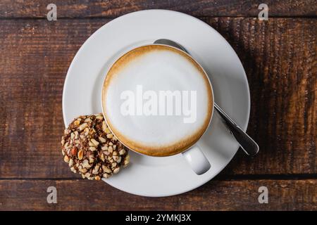 Cappuccino-Kaffee in weißer Porzellantasse auf Holztisch Stockfoto