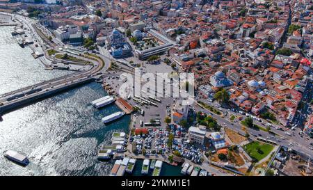 Blick aus der Vogelperspektive auf Istanbuls Galata-Brücke, die pulsierende Viertel verbindet, mit Booten, Autos und Fußgängern unter der türkischen Sonne Stockfoto