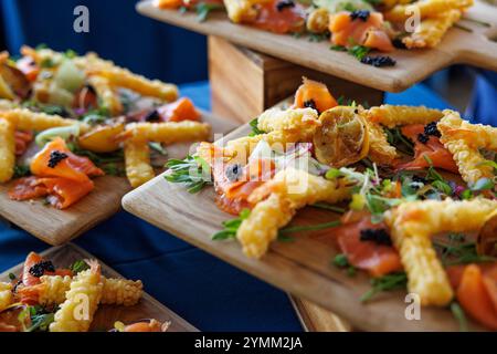 Ein Tisch voller Speisen mit einer Vielzahl von Gerichten einschließlich frittierte Speisen, Gemüse und Obst. Die Präsentation ist elegant und einladend Stockfoto