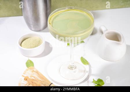 Cremiger Matcha-Martini-Cocktail Matchatini, trendiger kalter Sommercocktail. Matcha alkoholfreier Mocktail oder Alkohol Cocktail, in Martini Gläsern mit GREE Stockfoto