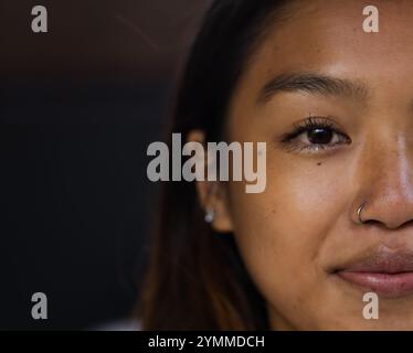 Nahaufnahme einer asiatischen Teenagerin, die mit Nasenring und Ohrringen lächelt, Kopierraum, zu Hause. Mode, Stil, Schmuck, Porträt, Ausdruck, Zubehör Stockfoto
