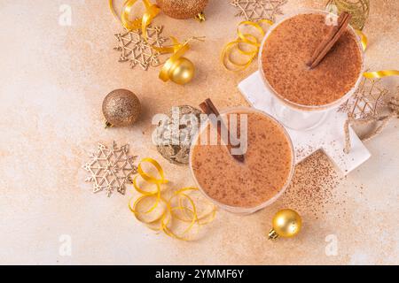 Eierpunsch-Martini-Cocktail mit Zimt und Muskatnuss, goldene Weihnachtsdekorationen und Bokeh-Effekt, Kopierbereich Stockfoto