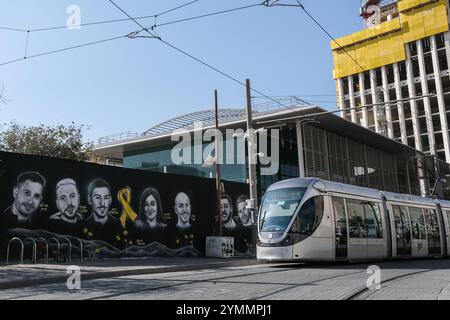 Jerusalem, Israel. November 2024. Ein riesiges Wandgemälde des israelischen Künstlers Benzi Brofman zeigt die Porträts von sieben entführten Bewohnern der Gegend um Jerusalem vor Zehntausenden von täglich Reisenden, die den Bahnhof Yitzhak Navon, den zentralen Busbahnhof und die Stadtbahn in Jerusalem passieren. Zu sehen sind Porträts von Avinathan oder Elia Cohen, Eitan Mor, Karina Ariev, Rom Breslavsky, Elkana Bohbot und der verstorbene Uriel Baruch, da 101 israelische Geiseln in Gefangenschaft der Hamas in Gaza verbleiben, jetzt 412 Tage. Quelle: Nir Alon/Alamy Live News Stockfoto