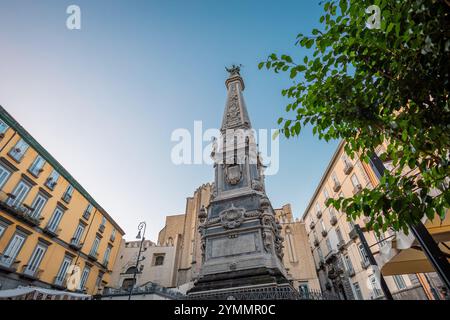 Piazza oder Platz von San Domenico Maggiore in Neapel, Italien. Wunderschöner Marmorturm, der sich an einem sonnigen Herbstabend mitten auf dem Platz erhebt Stockfoto