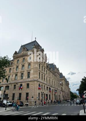 Paris, Frankreich - 19. Juni 2024: Ein klassisches Steingebäude mit französischen Flaggen steht an prominenter Stelle in einer urbanen Straße, französischer Architektur und Kultur Stockfoto