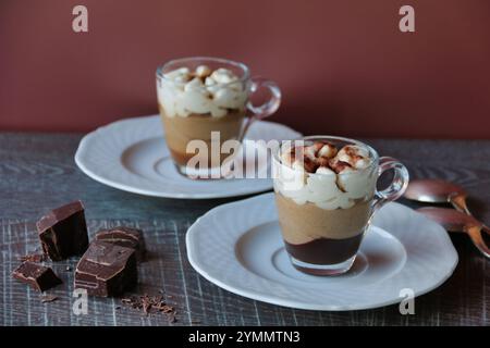 Zwei Tassen Kaffeesahne mit Schlagsahne auf Holztisch Stockfoto