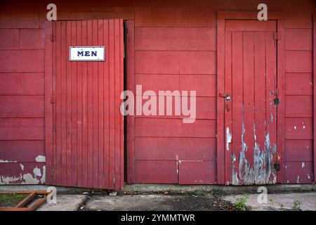 Rustikale Männer-Toilette in Rot gestrichen Stockfoto