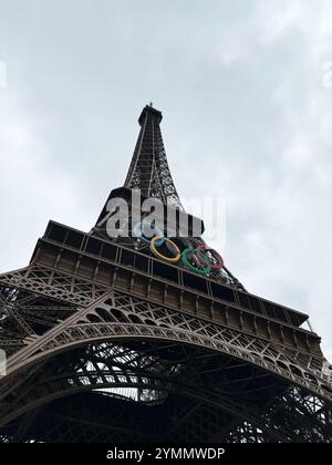 Paris, Frankreich - 19. Juni 2024: Blick auf den ikonischen Eiffelturm mit olympischen Ringen vor einem bewölkten Pariser Himmel, der die globale Einheit widerspiegelt Stockfoto