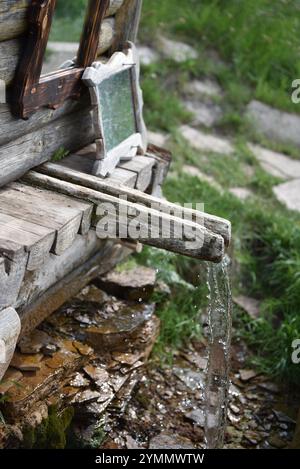 Rustikaler Holzbrunnen, der sanft fließt Stockfoto