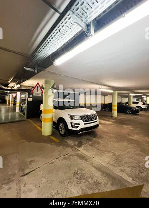 Budapest, Ungarn - 14. November 2024: Tiefgarage mit einem weißen Ford Explorer SUV, der an einem ausgewiesenen, gut beleuchteten Platz geparkt ist Stockfoto