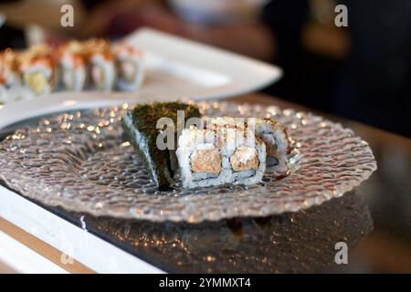 Nahaufnahme von Sushi auf einer Glasplatte, Bokeh-Hintergrund Stockfoto
