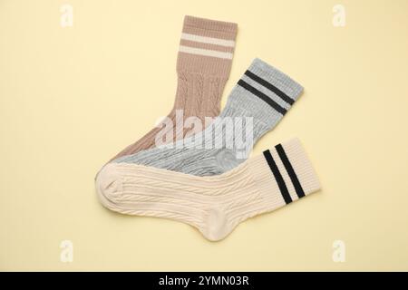 Verschiedene bequeme Socken auf beigefarbenem Hintergrund, flach geschnitten Stockfoto