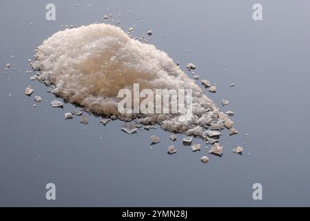 Stapel maldon-Salzflocken auf hellblauer reflektierender Oberfläche, Kopierraum Stockfoto