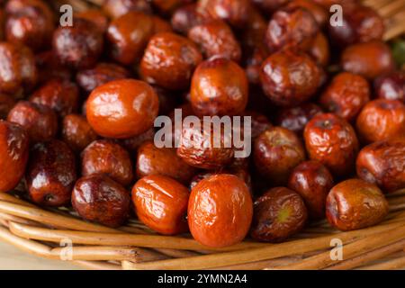 Selektiver Fokus auf eine große Gruppe von Jujubes-Früchten in einem Korb Stockfoto