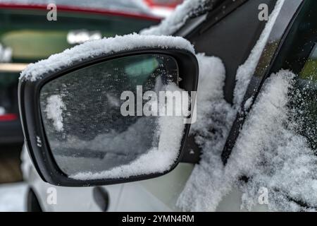 Vorbereitung des Fahrzeugs auf die Straße, Schneeräumen, Entfrosten der Spiegel, Entfernen von Eis aus den Spiegeln, Entfernen von Schnee aus den Spiegeln Stockfoto