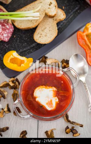 Fastenborsch mit getrockneten Pilzen und Gemüse auf einem hellen Holztisch. Stockfoto