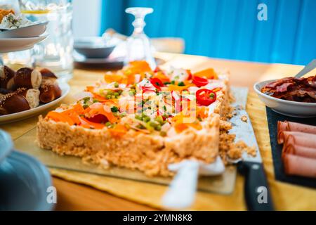 Eine lebendige Gemüsetorte garniert mit frischem Gemüse, einer Auswahl an Fleisch und Brot, wunderschön auf einem Frühstückstisch angeordnet, Creatin Stockfoto