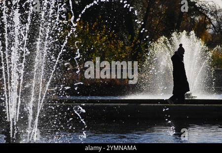 Ein Besucher der italienischen Gärten spaziert zwischen Springbrunnen im Hyde Park, London. Viele Briten sahen sich vor einem frostigen und eisigen Morgen und der Ankunft von Storm Bert am Wochenende erneut eiskalten Temperaturen ausgesetzt. Bilddatum: Freitag, 22. November 2024. Stockfoto