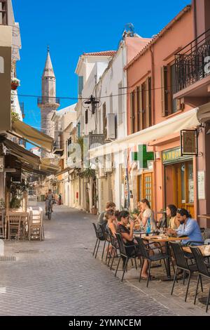 Griechenland Straßencafé, Blick auf Menschen, die im Sommer an Cafétischen essen und trinken, in einer Straße in der Altstadt von Chania (Hania), Kreta, Griechenland Stockfoto