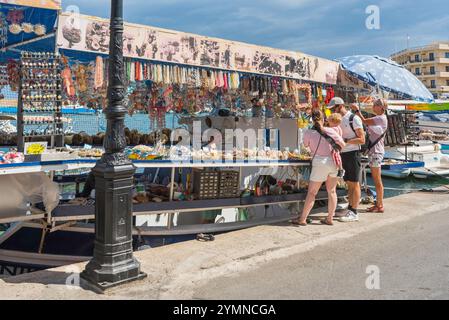 Griechenland Shopping, Blick auf Touristen, die in einem schwimmenden Souvenirladen in der Altstadt venezianischem Hafenviertel von Chania (Hania), Kreta, Griechenland, stöbern Stockfoto