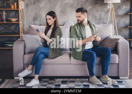 Foto von der jungen Frau, die getrennt auf Couch hoold Telefone sitzt Loft Innenwohnung Wohnung drinnen Stockfoto